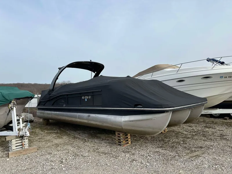 Slide: The Image of 2016 Bennington 2875 QCW I/O pontoon boat covered and stored on blocks. - 1