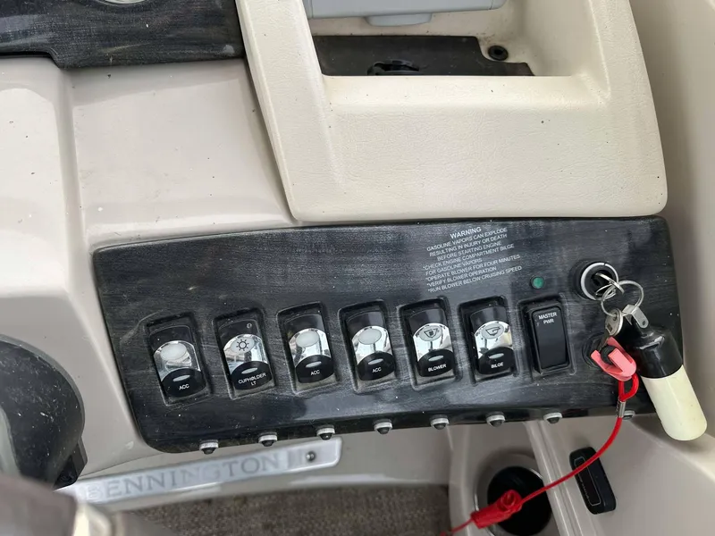 Slide: The Image of Control panel of a 2016 Bennington 2875 QCW I/O boat with switches and ignition key. - 16