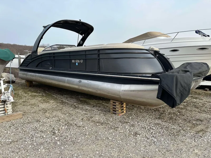Slide: The Image of 2016 Bennington 2875 QCW I/O pontoon boat on dry land, covered and elevated. - 19