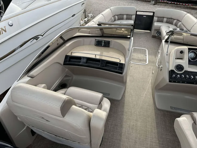 Slide: The Image of 2016 Bennington 2875 QCW I/O boat interior with beige seating and dashboard. - 23