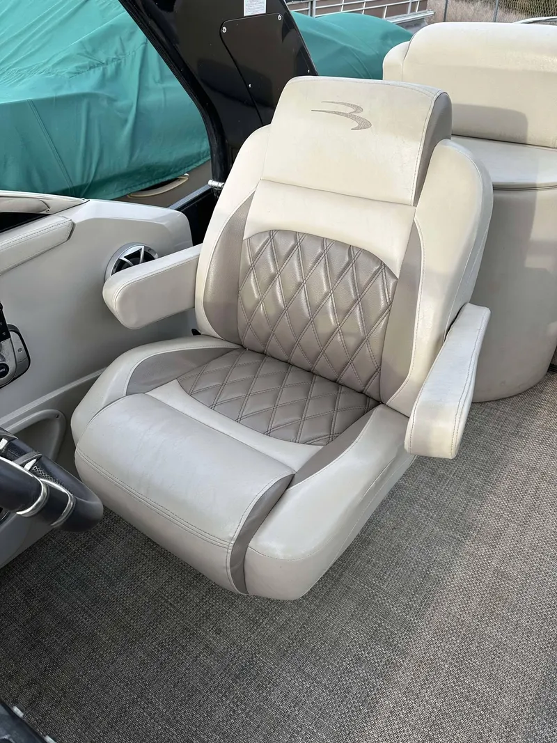 Slide: The Image of Captain's chair in a 2016 Bennington 2875 QCW I/O boat, featuring diamond-pattern upholstery. - 25
