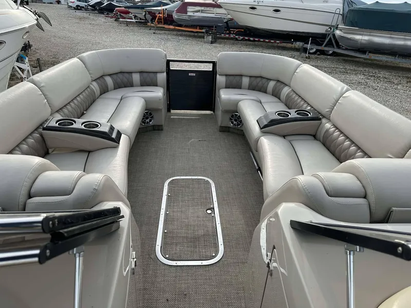 Slide: The Image of 2016 Bennington 2875 QCW I/O pontoon boat interior with plush seating and cup holders. - 31