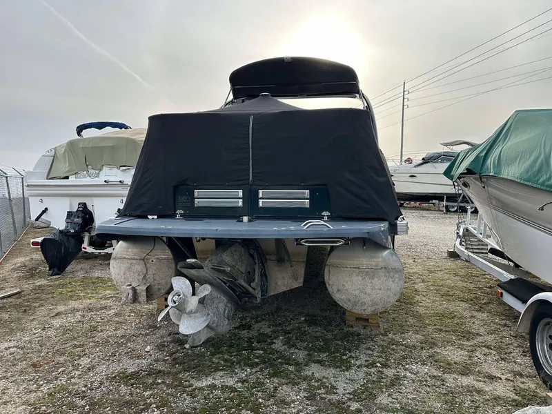 Slide: The Image of 2016 Bennington 2875 QCW I/O pontoon boat with cover, parked on gravel lot. - 32