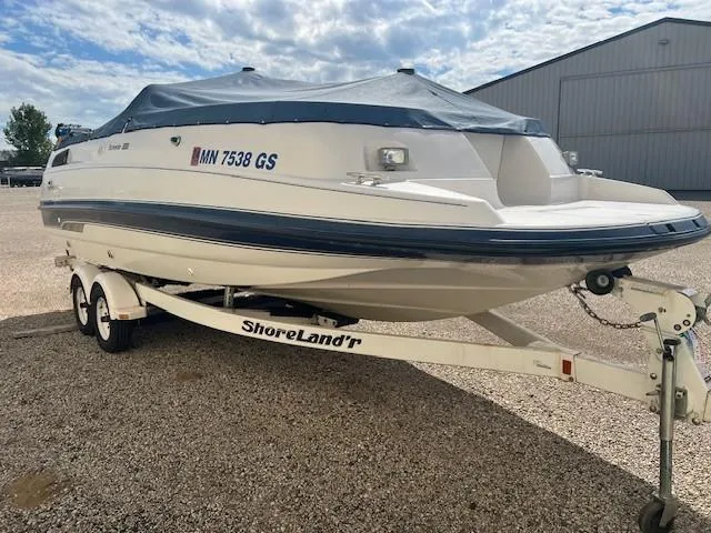 The Image of 1995 Chaparral 220 Sunseta boat on trailer with cover, parked outdoors. - 0