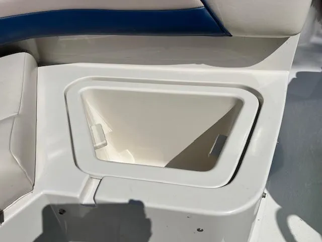 Slide: The Image of Storage compartment on a 1995 Chaparral 220 Sunseta boat, featuring white and blue interior. - 6