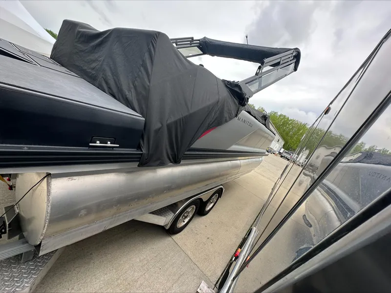 Slide: The Image of 2023 Manitou Explore pontoon boat covered, on trailer, parked outdoors. - 6