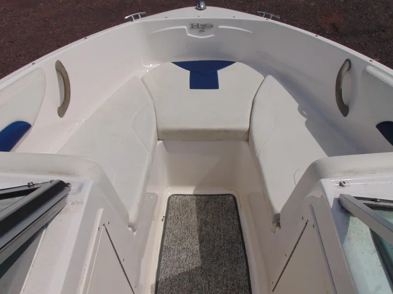 Slide: The Image of 2015 Chaparral 18 H2O Sport boat interior with white seating and blue accents. - 10