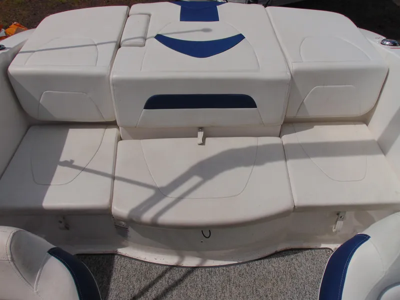 Slide: The Image of 2015 Chaparral 18 H2O Sport boat interior seating with white and blue upholstery. - 12