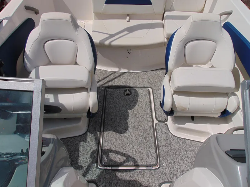 Slide: The Image of 2015 Chaparral 18 H2O Sport boat interior with white seating and gray carpet. - 15