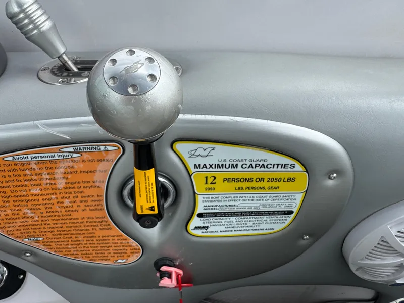 Slide: The Image of 2007 Nautique Super Air Nautique 230 control panel with capacity warning labels. - 12