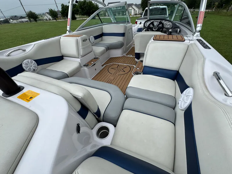Slide: The Image of 2007 Nautique Super Air Nautique 230 interior with white and blue seating, wood accents. - 17