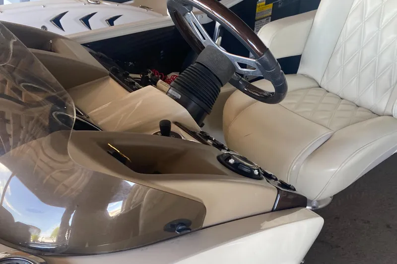 Slide: The Image of Interior of a 2012 Bennington R22 boat with steering wheel and beige seating. - 11