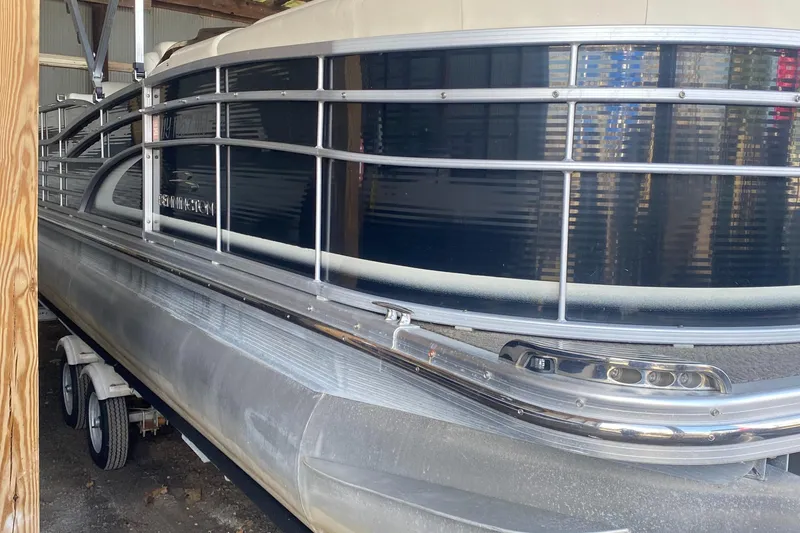 Slide: The Image of 2012 Bennington R22 pontoon boat in storage, side view with metal railings. - 13