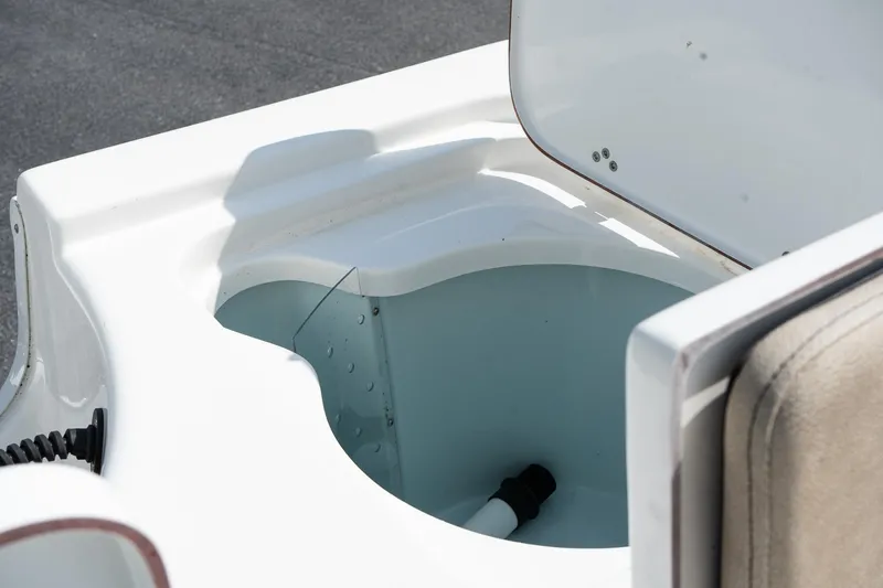 Slide: The Image of 2023 Sea Pro 208 Bay boat storage compartment with open lid, showcasing interior details. - 13
