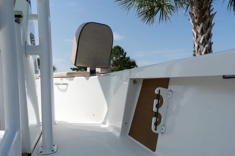 Slide: The Image of 2023 Sea Pro 208 Bay boat interior with seating and storage, under a clear blue sky. - 15