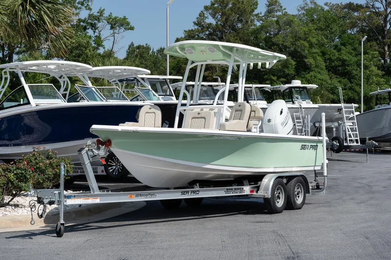 Slide: The Image of 2023 Sea Pro 208 Bay boat on trailer, parked in marina with other boats. - 3
