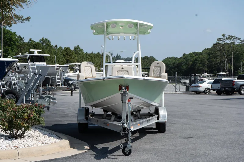 Slide: The Image of 2023 Sea Pro 208 Bay boat on trailer in parking lot, surrounded by trees and vehicles. - 4