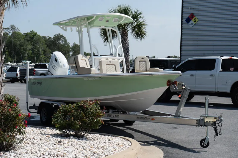 Slide: The Image of 2023 Sea Pro 208 Bay boat on trailer, parked outdoors near palm trees. - 5
