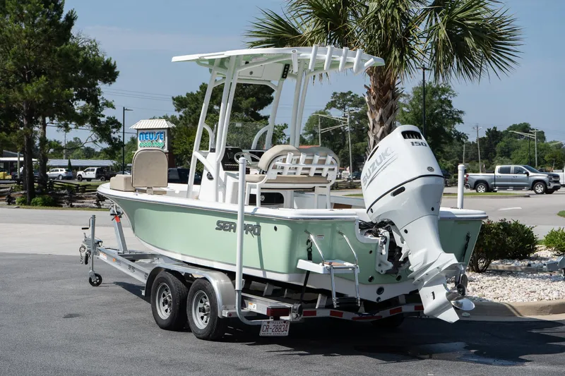 Slide: The Image of 2023 Sea Pro 208 Bay boat on trailer, parked outdoors near palm trees. - 6
