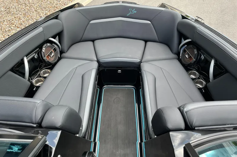 Slide: The Image of 2018 MasterCraft XStar boat interior with gray seating and built-in speakers. - 12