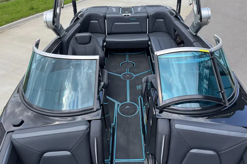 Slide: The Image of 2018 MasterCraft XStar boat interior with sleek black seating and blue accents. - 13