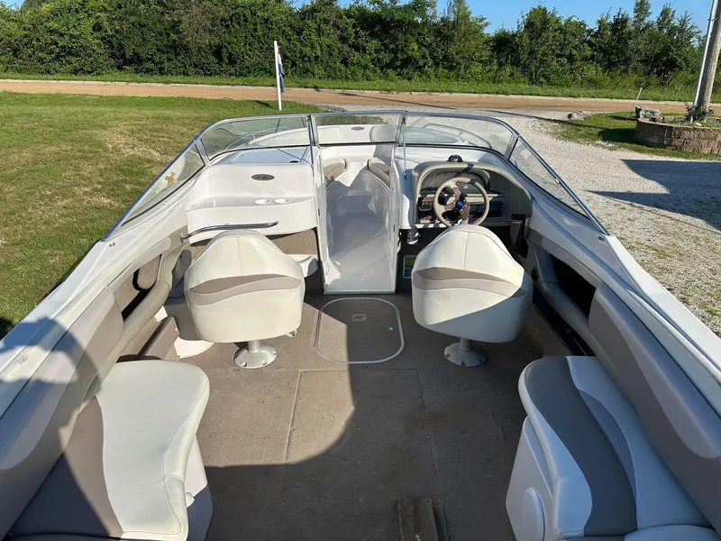 Slide: The Image of 1997 Four Winns 240 Horizon boat interior with seating and steering wheel, parked on grass. - 14