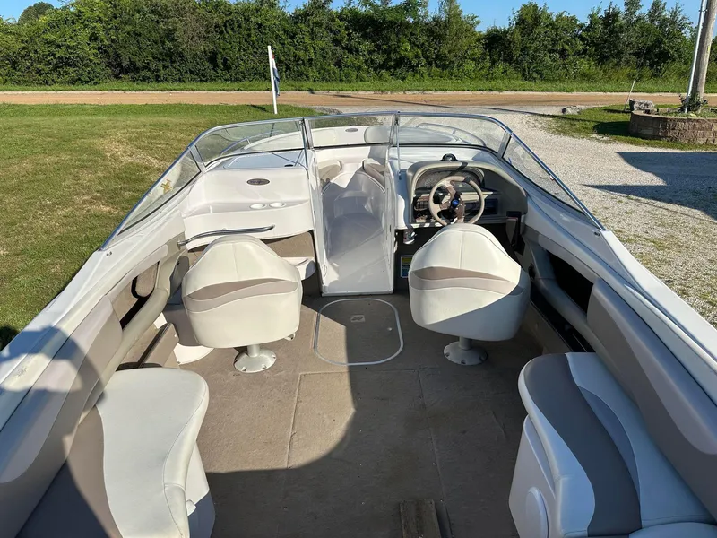 Slide: The Image of 1997 Four Winns 240 Horizon boat interior with seating and steering wheel, parked on grass. - 3