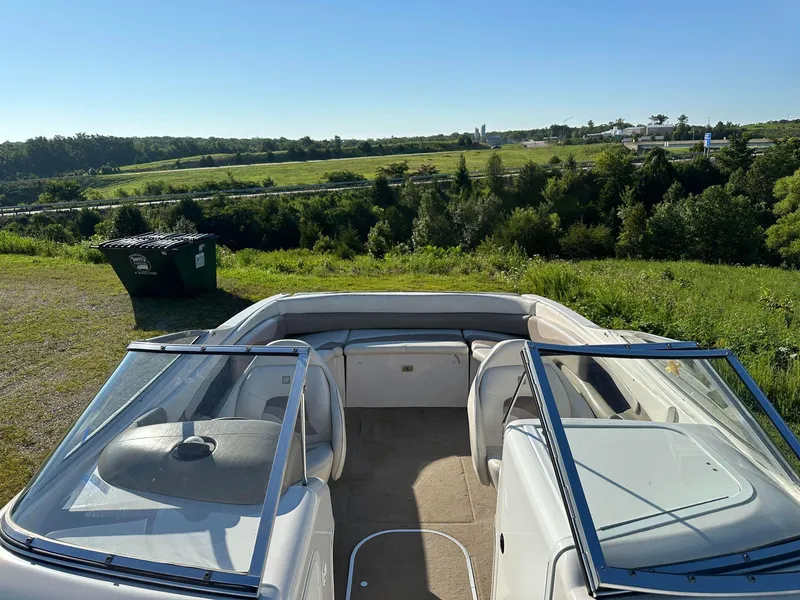 Slide: The Image of 1997 Four Winns 240 Horizon boat with open seating, parked on grassy hill. - 5