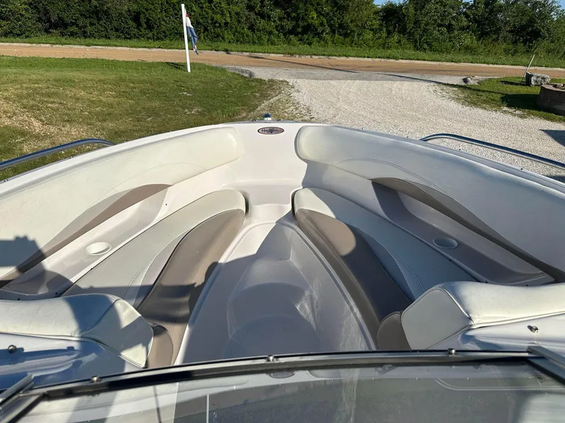 Slide: The Image of 1997 Four Winns 240 Horizon boat interior with white and beige seating, parked on grass. - 6