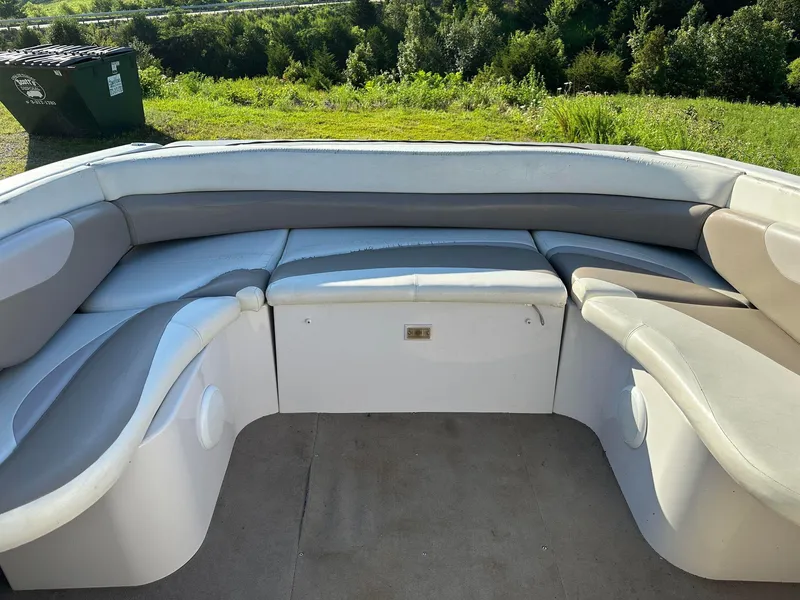 Slide: The Image of 1997 Four Winns 240 Horizon boat interior with cushioned seating and scenic outdoor view. - 8