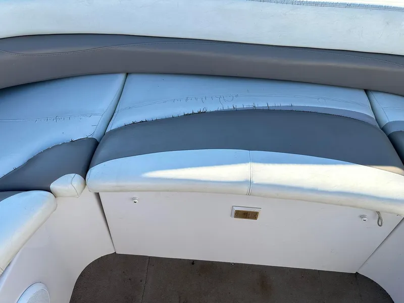 Slide: The Image of 1997 Four Winns 240 Horizon boat seating with visible wear and tear on upholstery. - 9