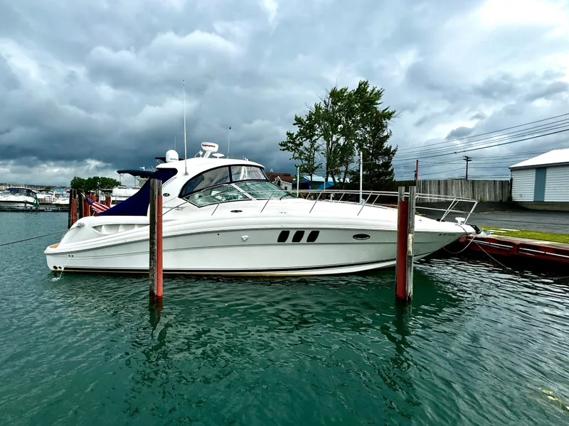 Slide: The Image of 2010 Sea Ray 40 Sundancer yacht docked in a marina under cloudy skies. - 0