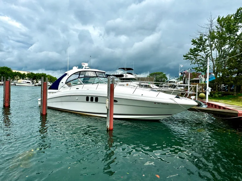 Slide: The Image of 2010 Sea Ray 40 Sundancer yacht docked in a marina under cloudy skies. - 1