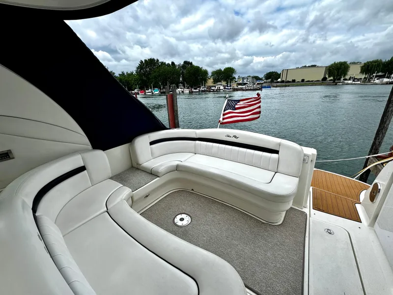 Slide: The Image of 2010 Sea Ray 40 Sundancer yacht with American flag, docked by a serene waterfront. - 10