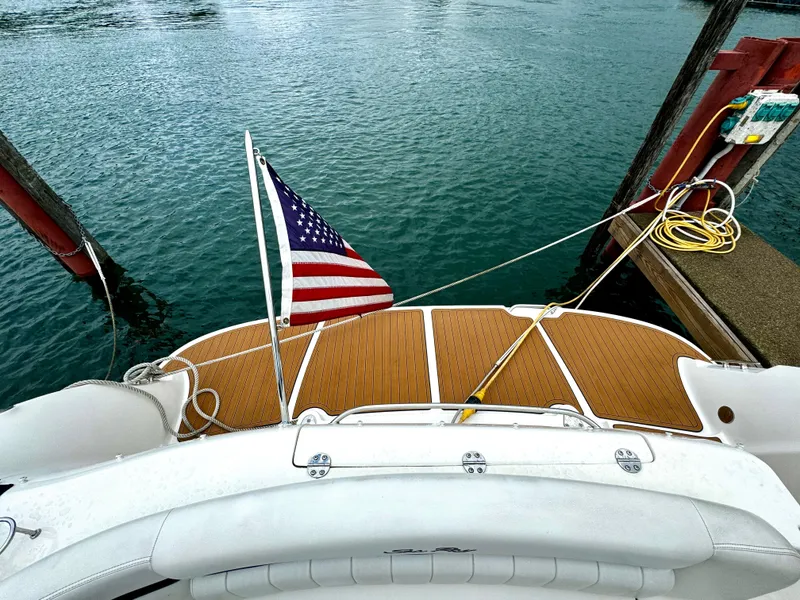 Slide: The Image of 2010 Sea Ray 40 Sundancer boat with American flag docked on calm water. - 11
