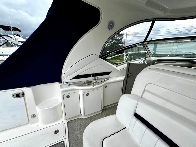 Slide: The Image of 2010 Sea Ray 40 Sundancer interior with white seating and compact kitchenette. - 15
