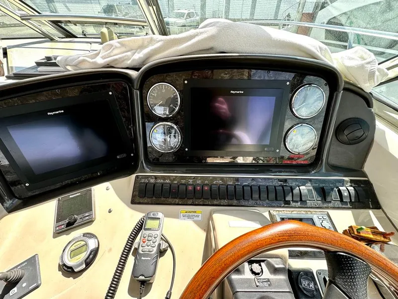 Slide: The Image of Dashboard of a 2010 Sea Ray 40 Sundancer yacht with navigation screens and controls. - 21