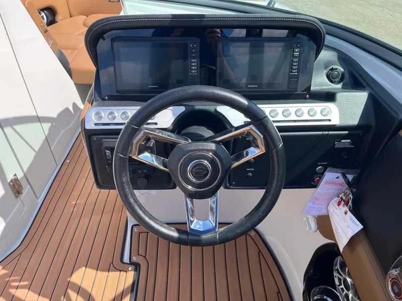Slide: The Image of 2024 Crownline Eclipse E255 dashboard with steering wheel and dual displays. - 11