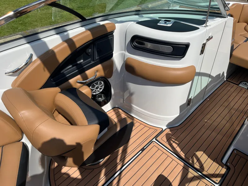Slide: The Image of 2024 Crownline Eclipse E255 boat interior with tan seating and wood-style flooring. - 13
