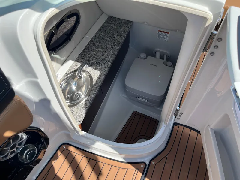 Slide: The Image of 2024 Crownline Eclipse E255 boat interior with sink and portable toilet. - 14