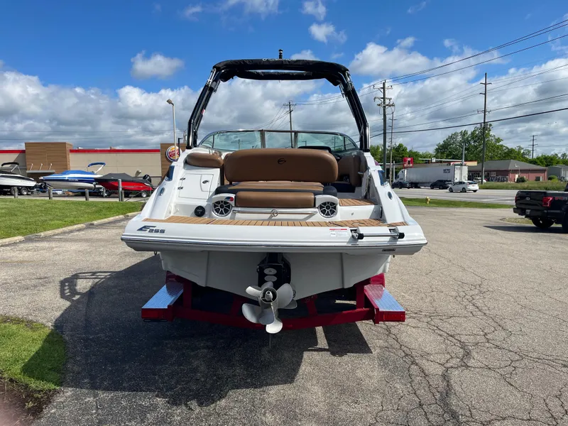 Slide: The Image of 2024 Crownline Eclipse E255 boat, rear view, parked outdoors on a sunny day. - 2