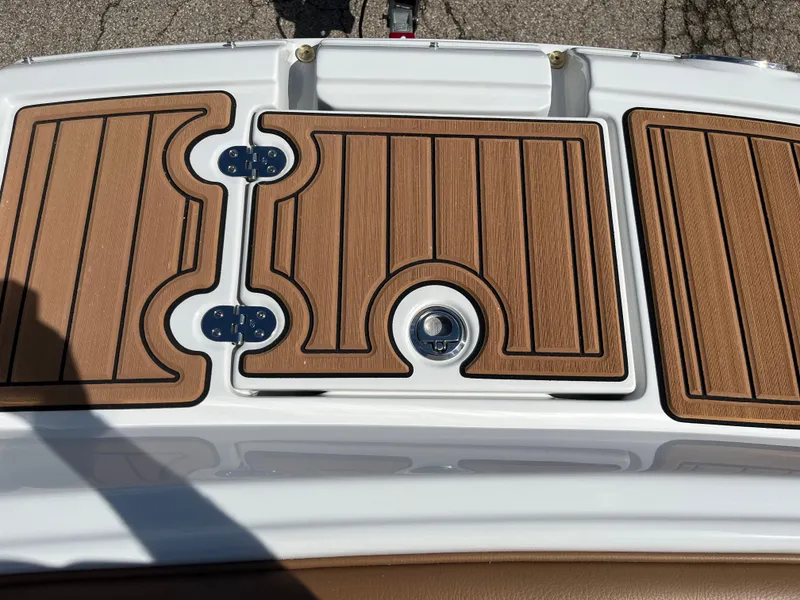 Slide: The Image of 2024 Crownline Eclipse E255 boat deck with wood finish and metal hinges. - 6