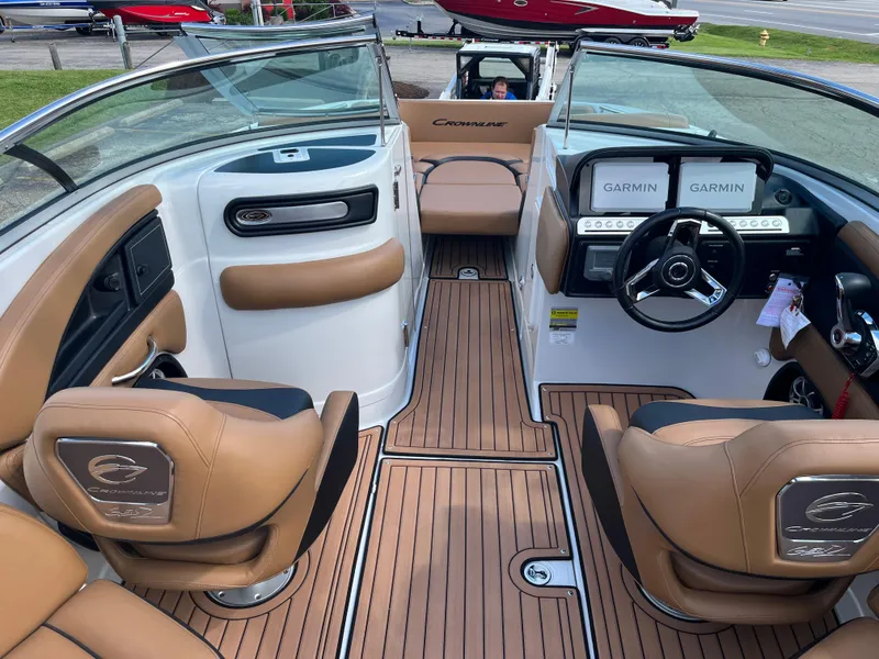 Slide: The Image of 2024 Crownline Eclipse E255 boat interior with tan seating and Garmin navigation system. - 9