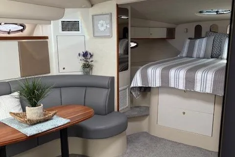 Slide: The Image of 1998 Cruisers 3870 Express cabin interior with bed, seating area, and wooden table. - 22