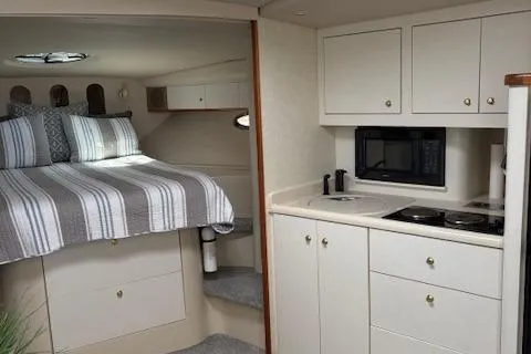 Slide: The Image of 1998 Cruisers 3870 Express interior with bed, kitchenette, and microwave. - 24