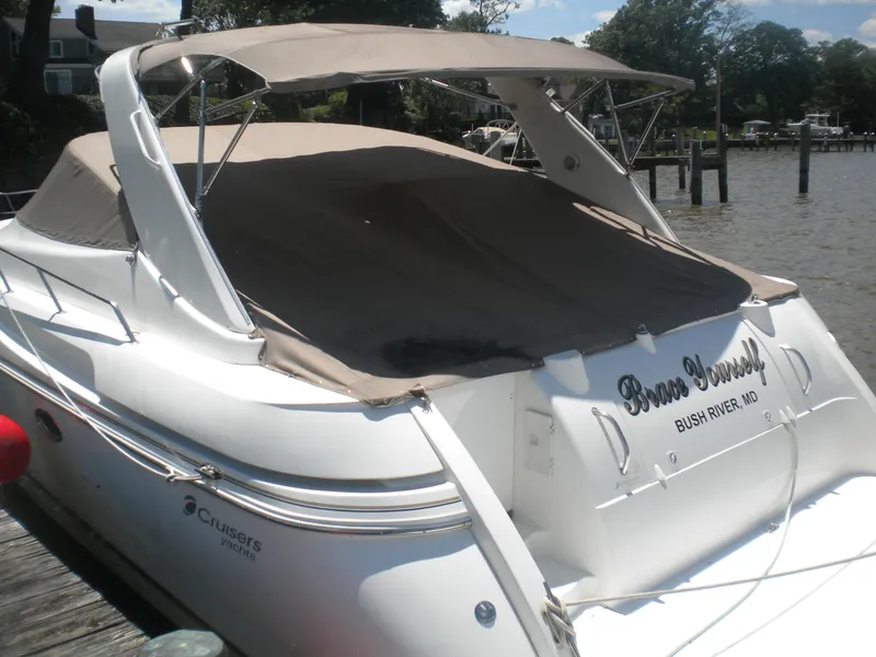 Slide: The Image of 1998 Cruisers 3870 Express yacht docked, featuring a covered deck and sleek design. - 5