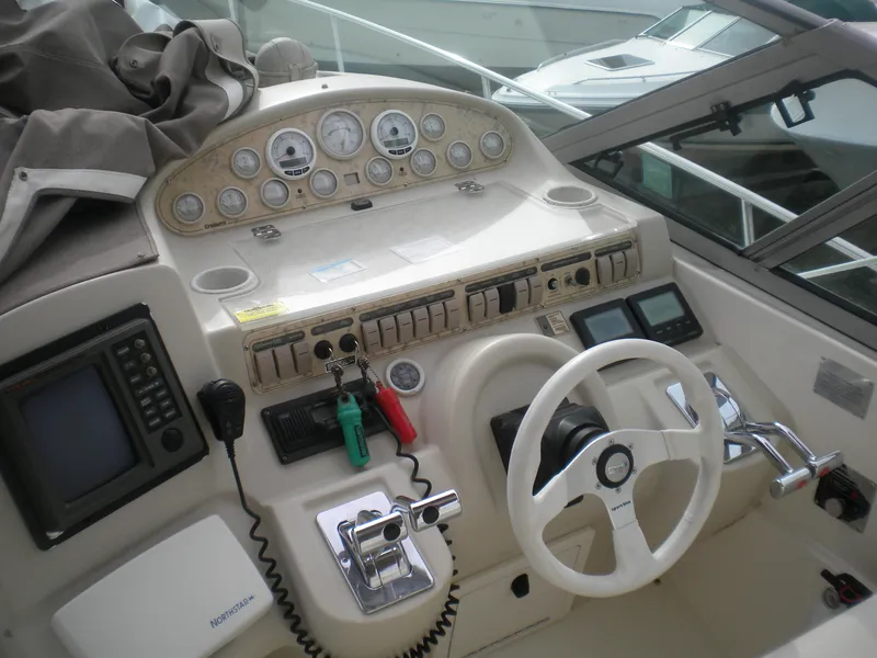 Slide: The Image of 1998 Cruisers 3870 Express boat helm with steering wheel and navigation controls. - 9
