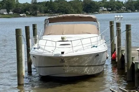 Slide: The Image of 1998 Cruisers 3870 Express docked on a calm lake with trees in the background. - 1
