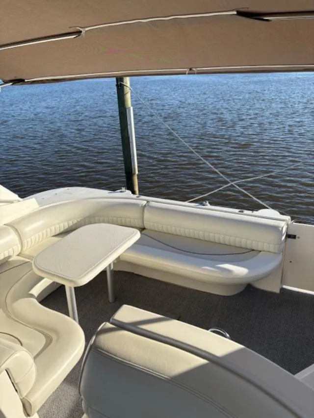 Slide: The Image of 1998 Cruisers 3870 Express boat with white seating and table, docked by calm water. - 16