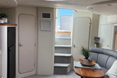 Slide: The Image of Interior of 1998 Cruisers 3870 Express yacht, featuring stairs, seating, and decor. - 19